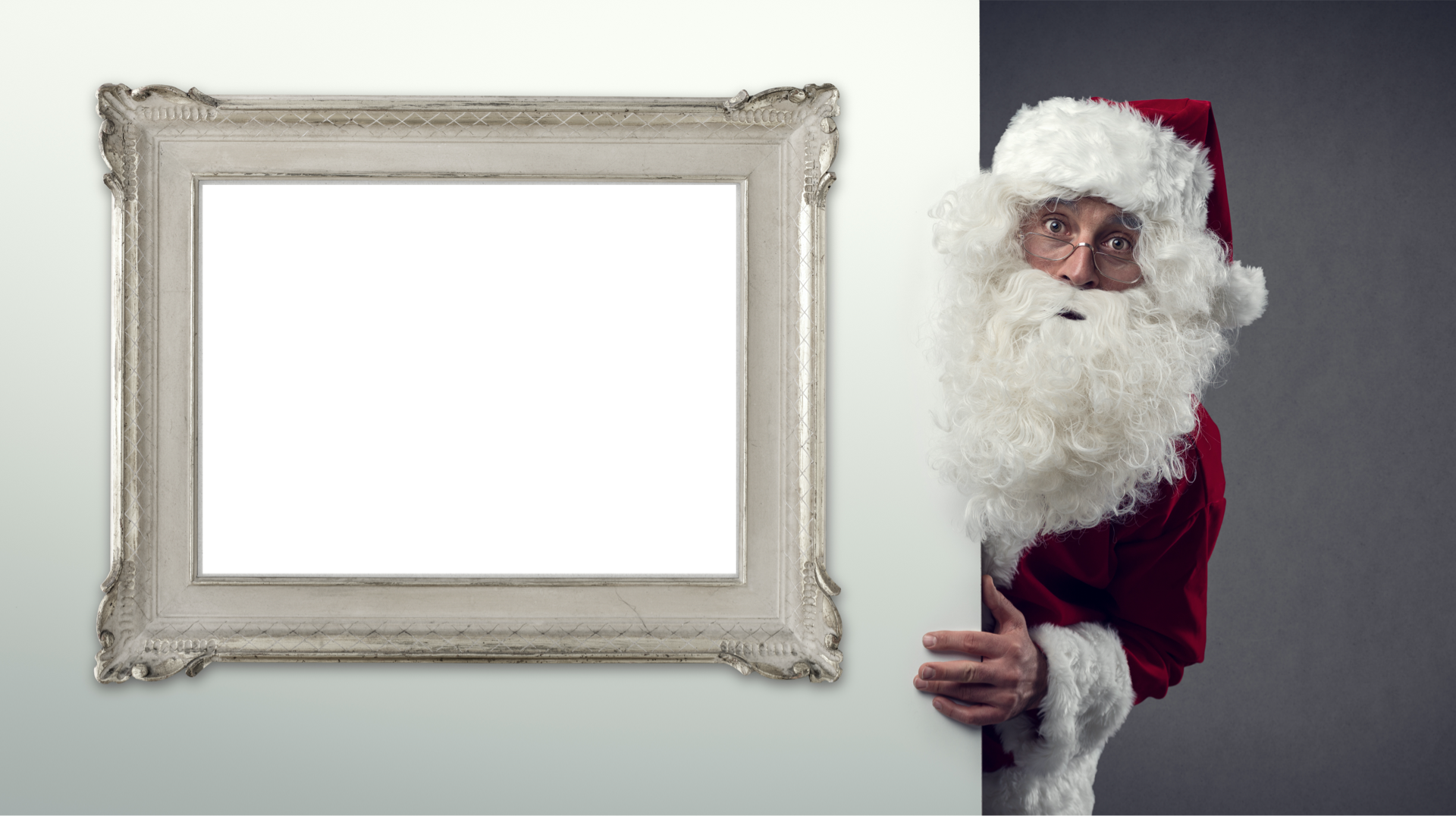Wall with hanging picture frame with Santa peeking around the corner
